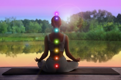 Image of Woman meditating in Lotus pose in nature, back view. Seven chakras glowing