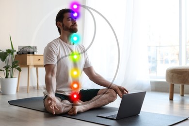 Image of Man meditating in Lotus pose at home. Seven chakras glowing. Yin-yang symbol around him