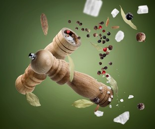 Image of Salt and pepper mills and spices flying against green gradient background