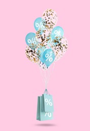 Image of Hot sale, special offer. Shopping bags and balloons with percent signs in air against pink background