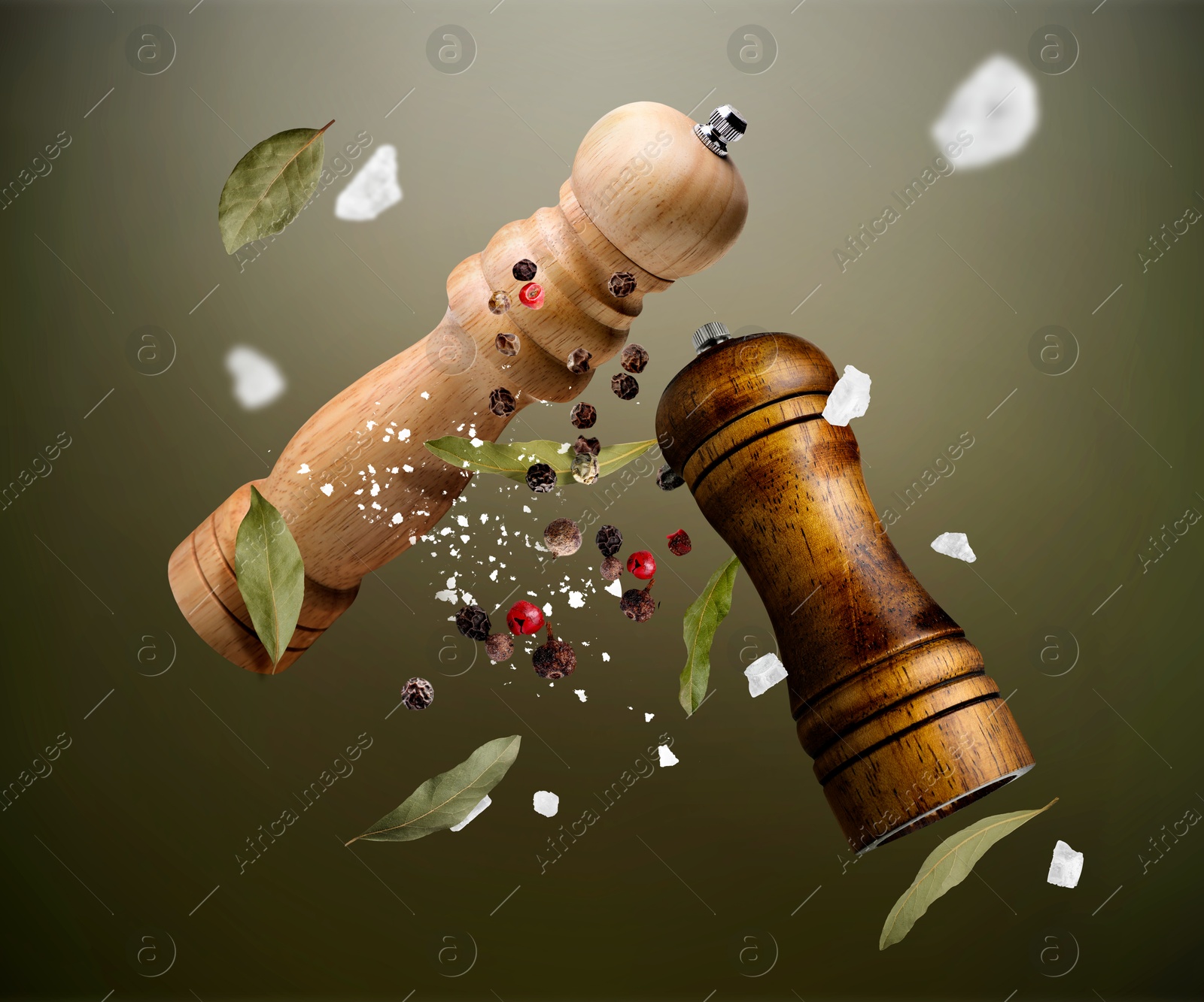 Image of Salt and pepper mills, bay leaves, coarse salt and peppercorns flying against olive gradient background