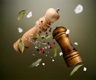 Image of Salt and pepper mills, bay leaves, coarse salt and peppercorns flying against olive gradient background