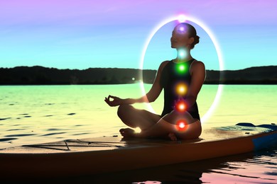 Image of Woman meditating in Lotus pose on SUP board. Aura seen as bubble around her. Seven chakras glowing