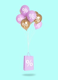 Image of Hot sale, special offer. Shopping bag and balloons with percent signs in air against light blue background