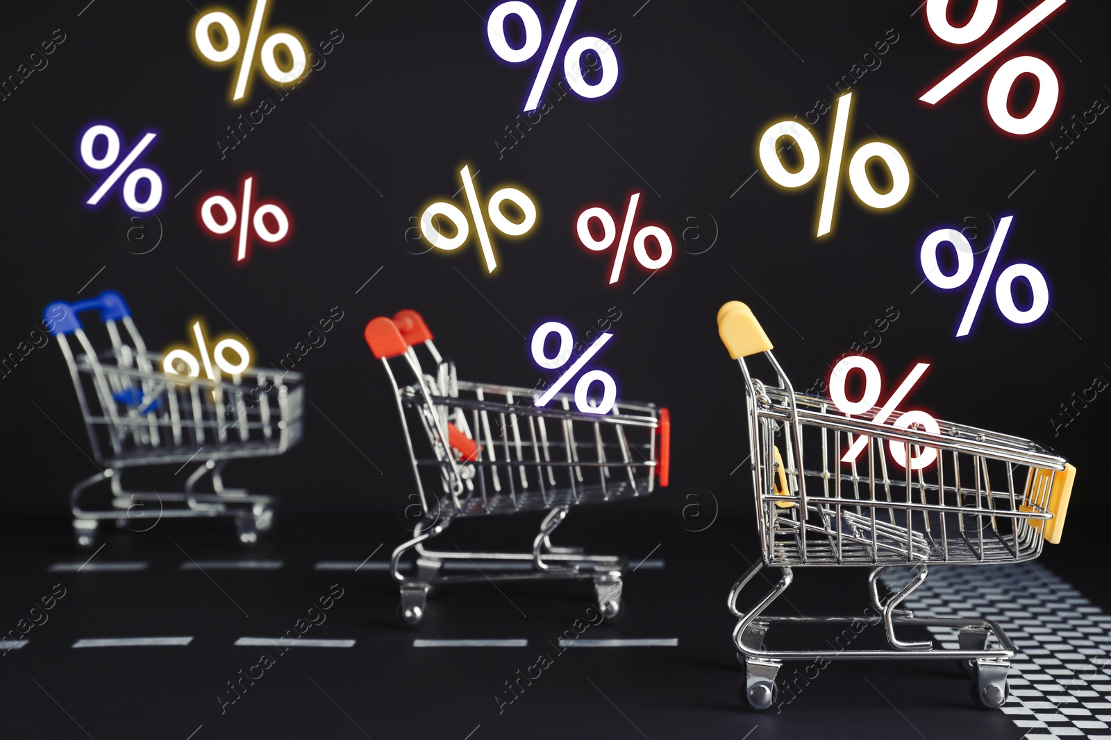 Image of Percent signs flying out of shopping carts racing on black background. Hot sale, special offer