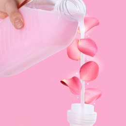 Image of Fabric softener advertising poster. Woman pouring conditioner against pink background. Flower petals flying around stream of liquid