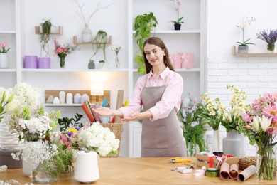 Photo of Professional florist working at wooden table in shop