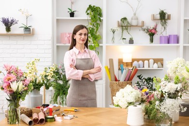 Photo of Professional florist working at wooden table in shop