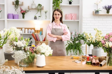 Photo of Professional florist working at wooden table in shop