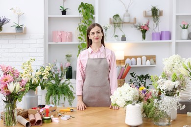 Photo of Professional florist working at wooden table in shop
