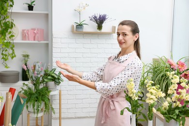 Photo of Portrait of professional florist with flowers in shop