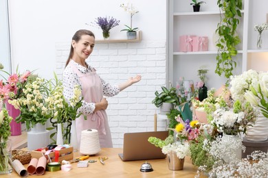Photo of Professional florist working at wooden table in shop