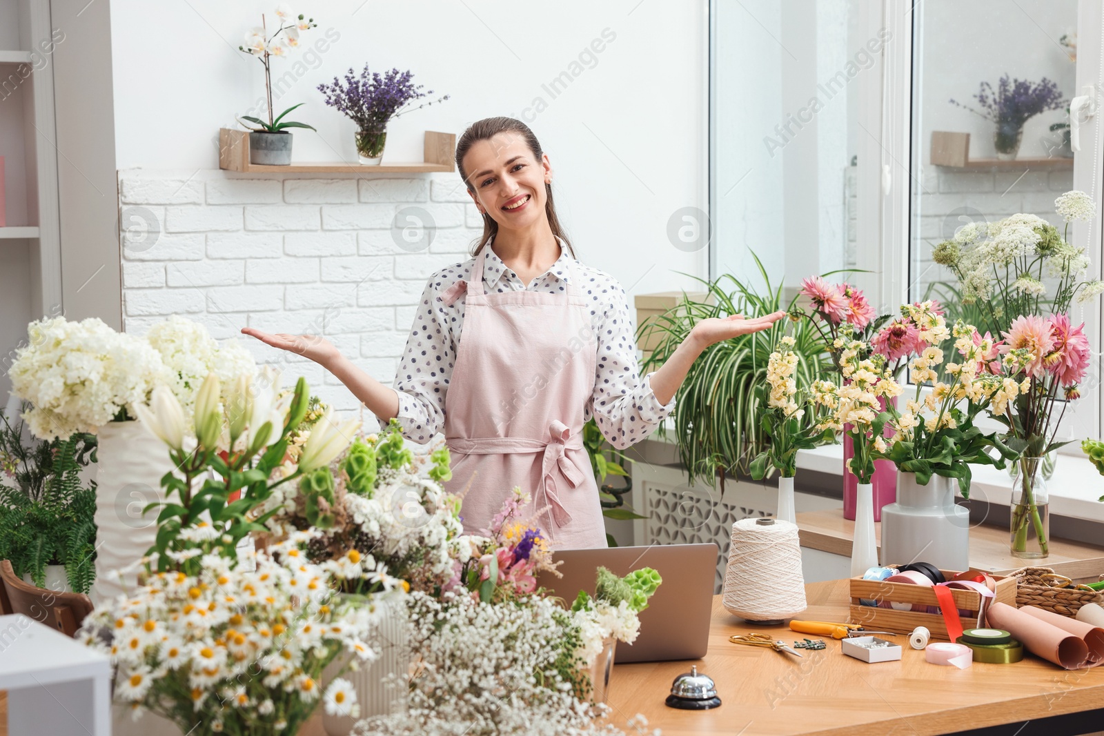 Professional florist working at wooden table in shop Photo of Professional florist working at wooden table in shop