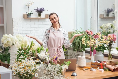 Photo of Professional florist working at wooden table in shop