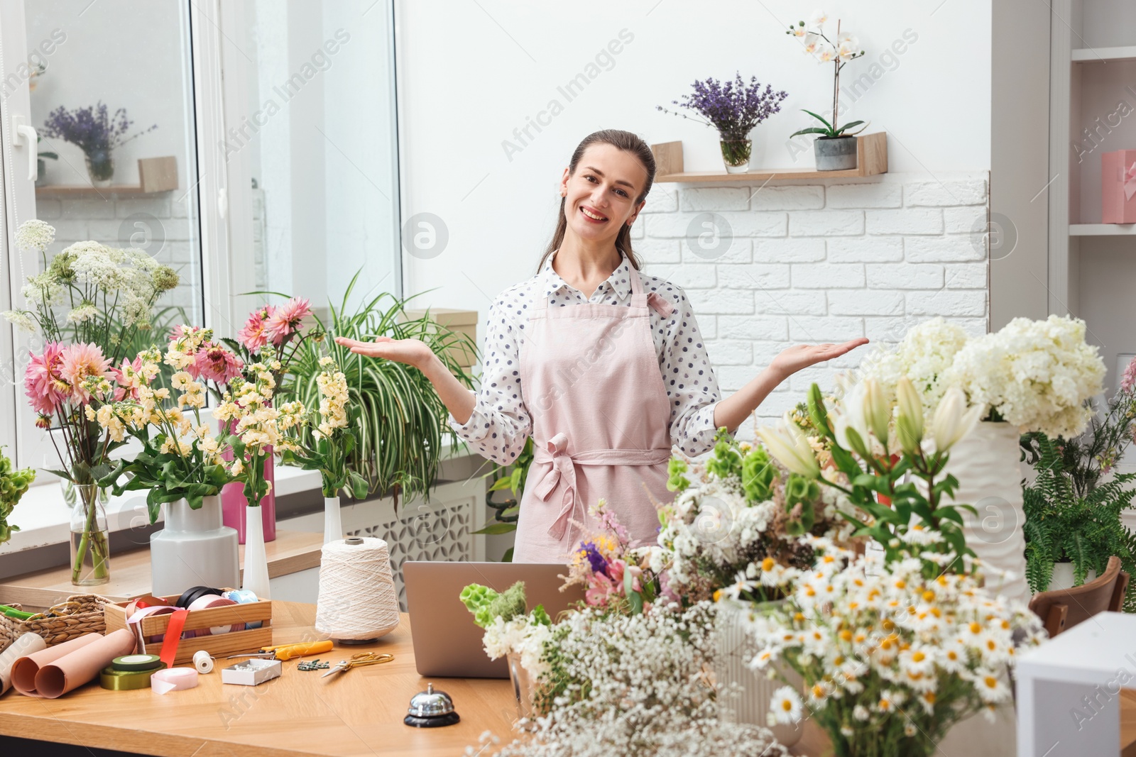 Professional florist working at wooden table in shop Photo of Professional florist working at wooden table in shop