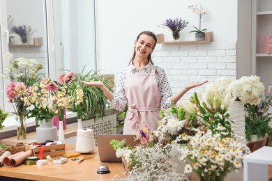 Photo of Professional florist working at wooden table in shop