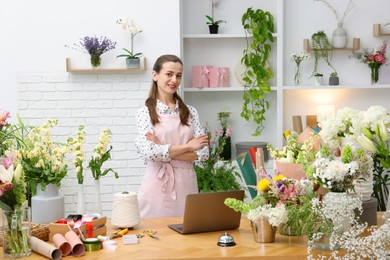 Photo of Professional florist working at wooden table in shop