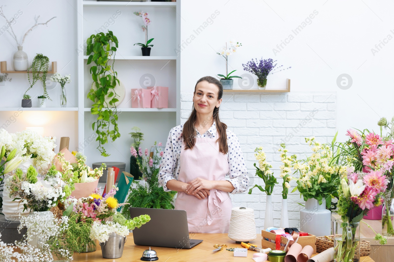 Professional florist working at wooden table in shop Photo of Professional florist working at wooden table in shop