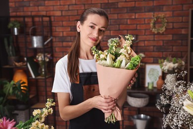 Photo of Professional florist with bouquet of flowers in shop