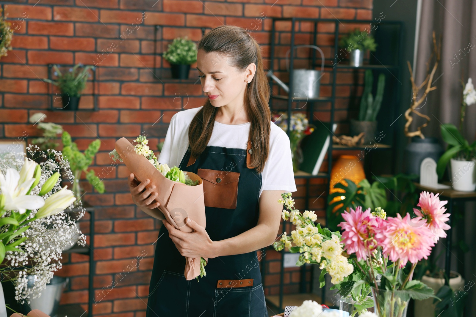 Professional florist with bouquet of flowers in shop Photo of Professional florist with bouquet of flowers in shop
