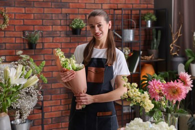 Photo of Professional florist with bouquet of flowers in shop