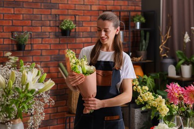 Photo of Professional florist with bouquet of flowers in shop