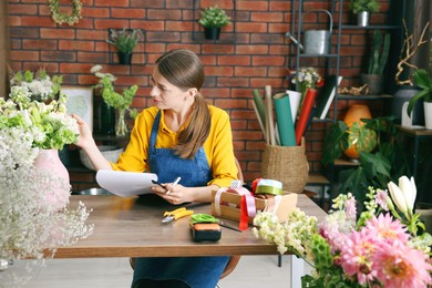 Photo of Professional florist working at wooden table in shop