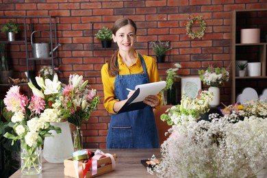 Photo of Professional florist working at wooden table in shop