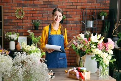Photo of Professional florist working at wooden table in shop
