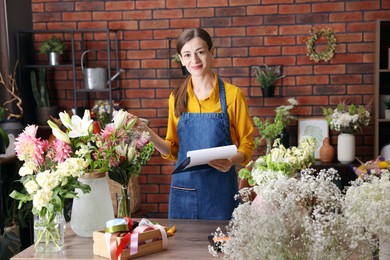 Photo of Professional florist working at wooden table in shop
