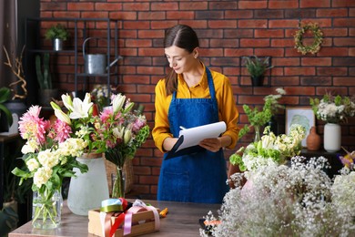 Photo of Professional florist working at wooden table in shop