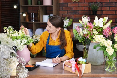 Photo of Professional florist working at wooden table in shop
