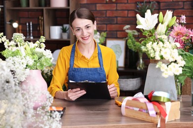 Photo of Professional florist working at wooden table in shop
