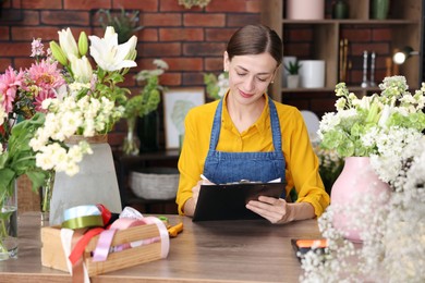 Photo of Professional florist working at wooden table in shop