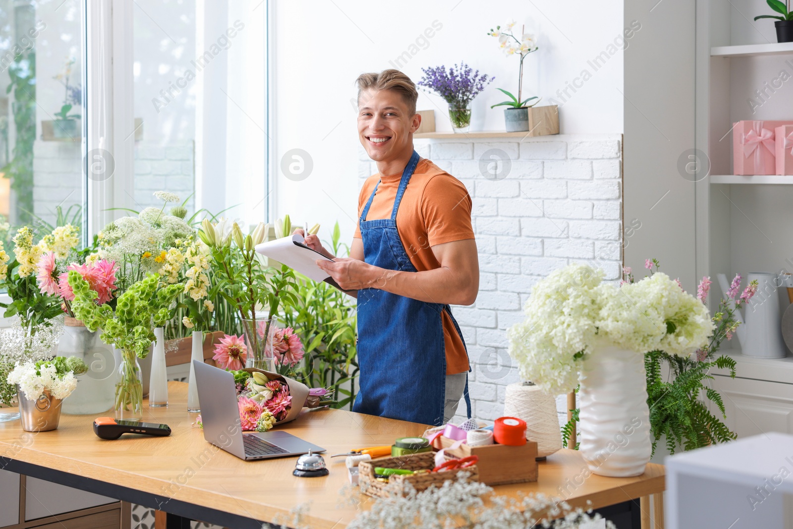 Photo of Professional florist working at wooden table in shop