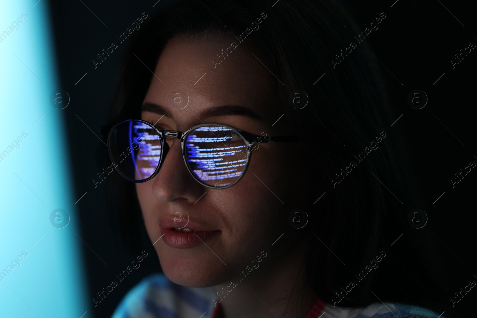Young woman wearing glasses with reflection on dark background, closeup Photo of Young woman wearing glasses with reflection on dark background, closeup