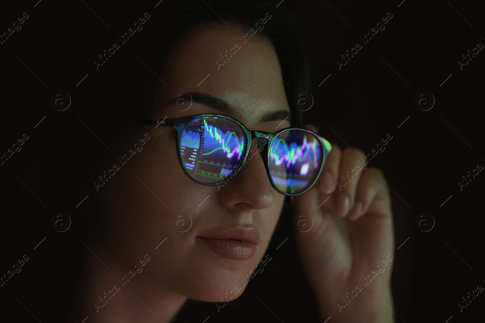 Young woman wearing glasses with reflection on dark background, closeup Photo of Young woman wearing glasses with reflection on dark background, closeup