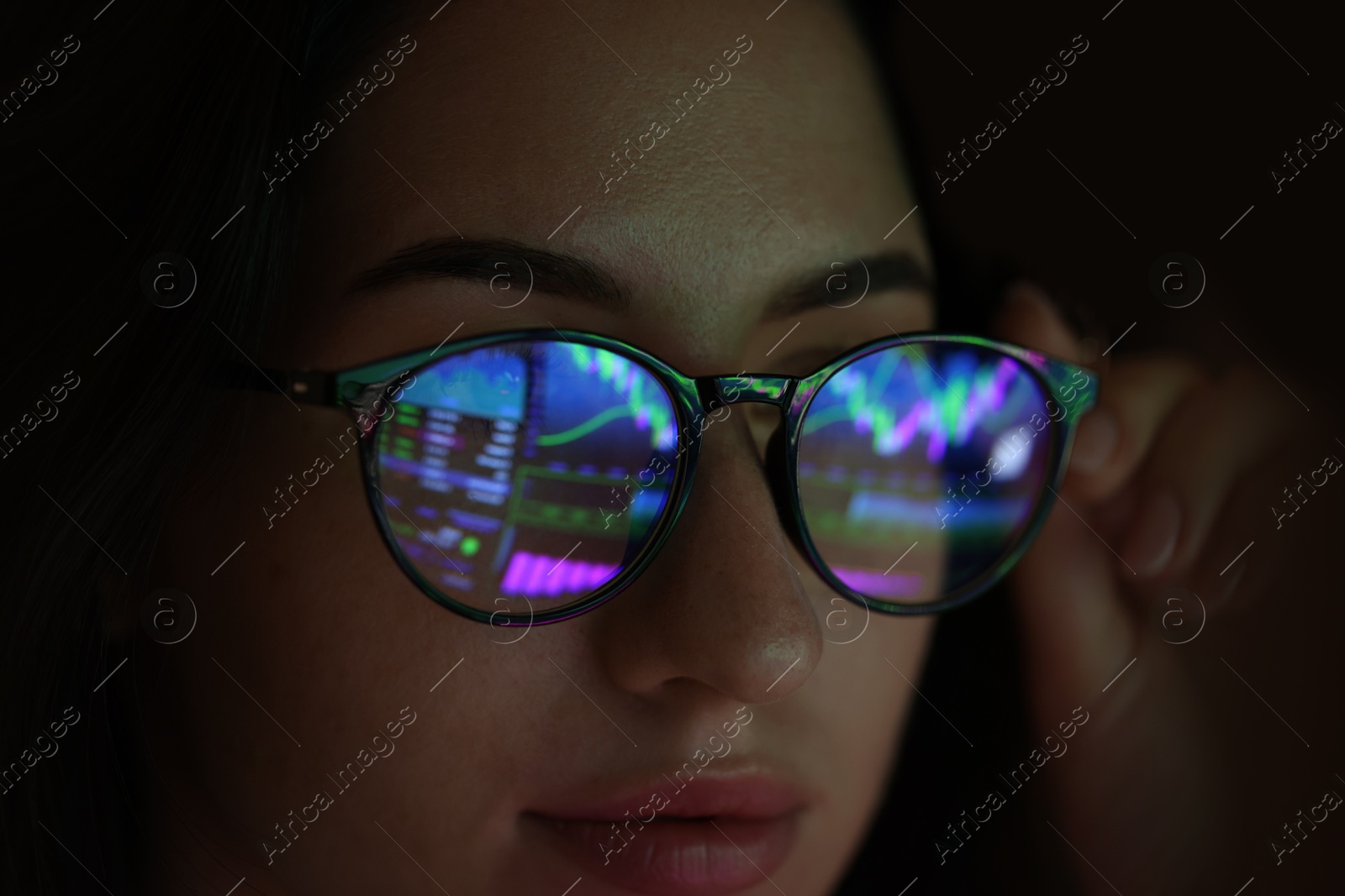 Young woman wearing glasses with reflection on dark background, closeup Photo of Young woman wearing glasses with reflection on dark background, closeup