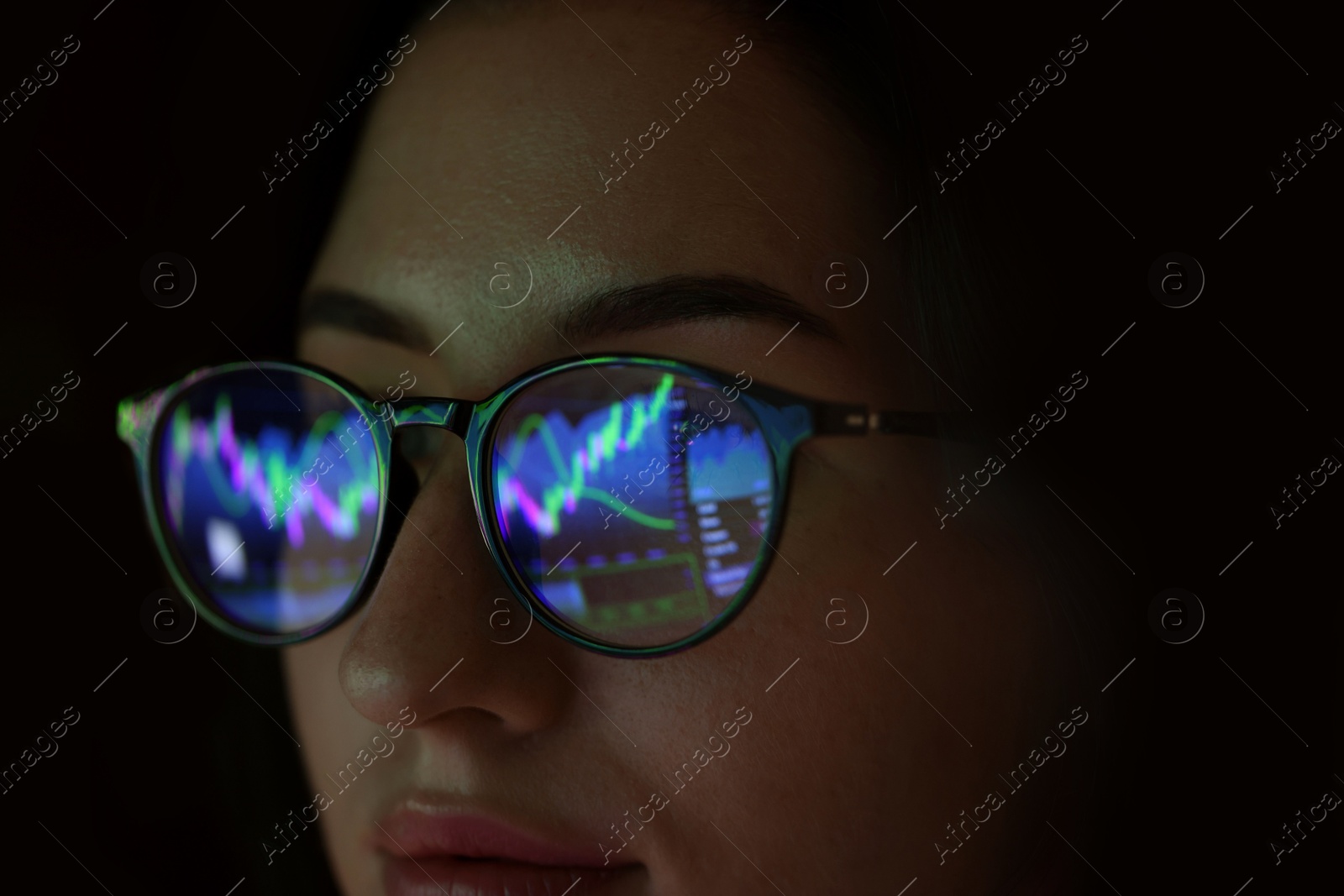 Young woman wearing glasses with reflection on dark background, closeup Photo of Young woman wearing glasses with reflection on dark background, closeup