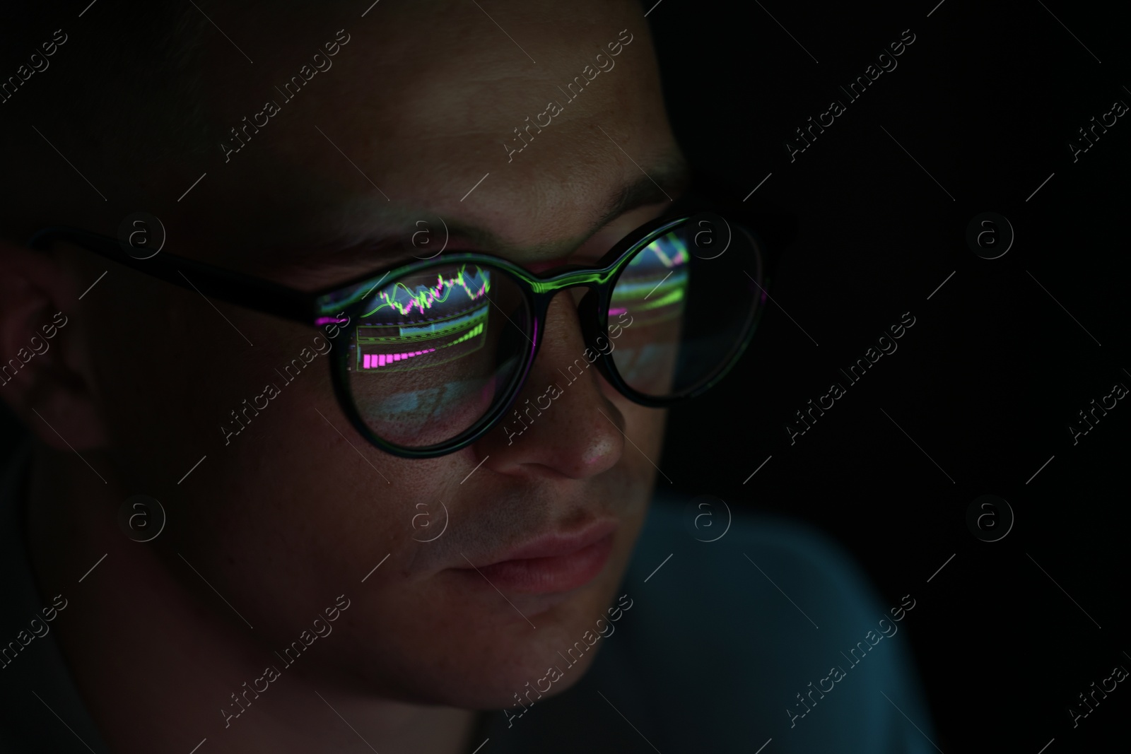Young man wearing glasses with reflection on dark background, closeup Photo of Young man wearing glasses with reflection on dark background, closeup