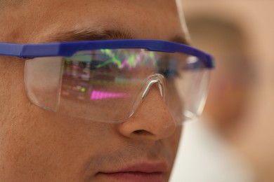 Photo of Young man wearing glasses with reflection on blurred background, closeup