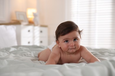 Photo of Cute little baby on bed at home, space for text