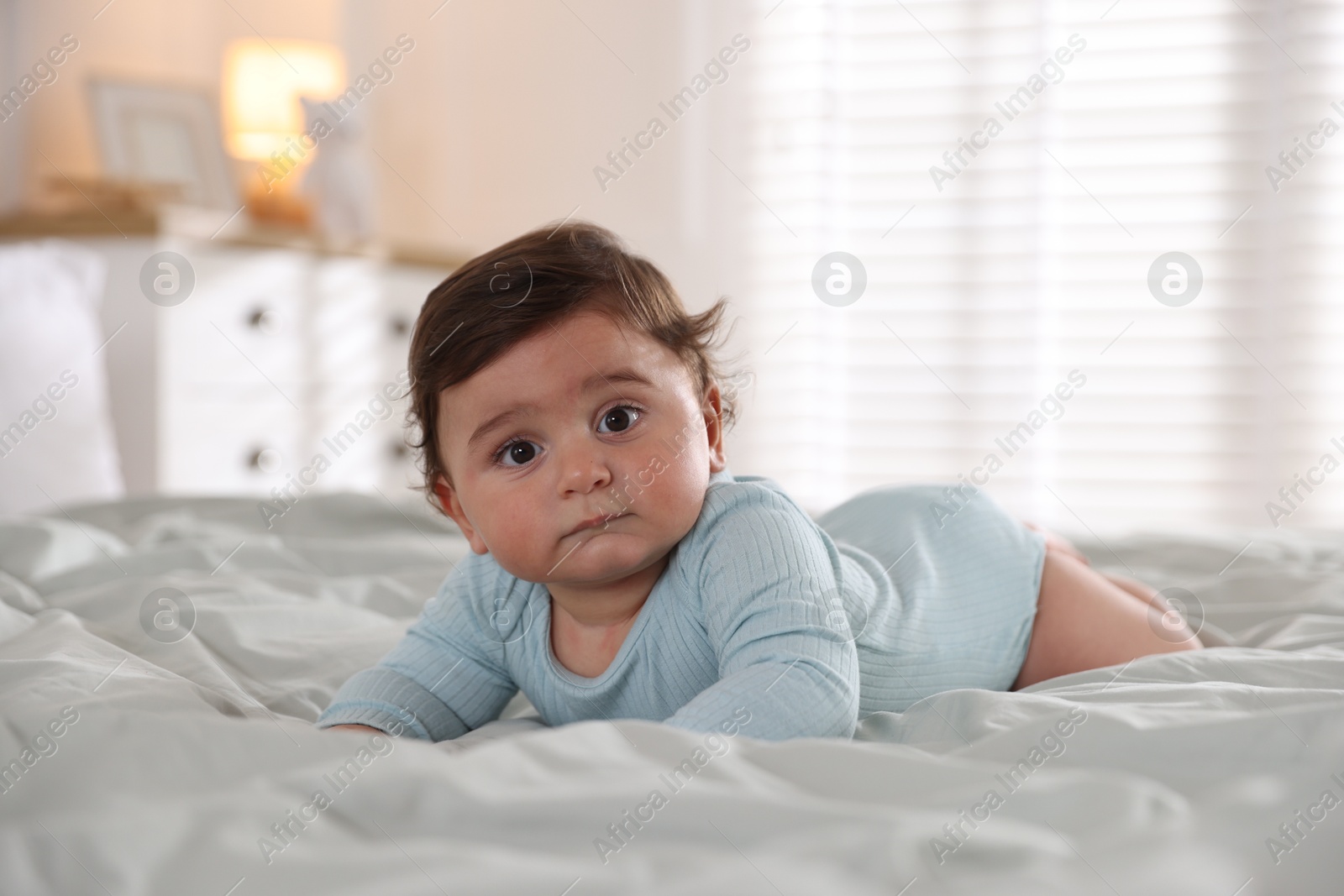 Photo of Cute little baby on bed at home