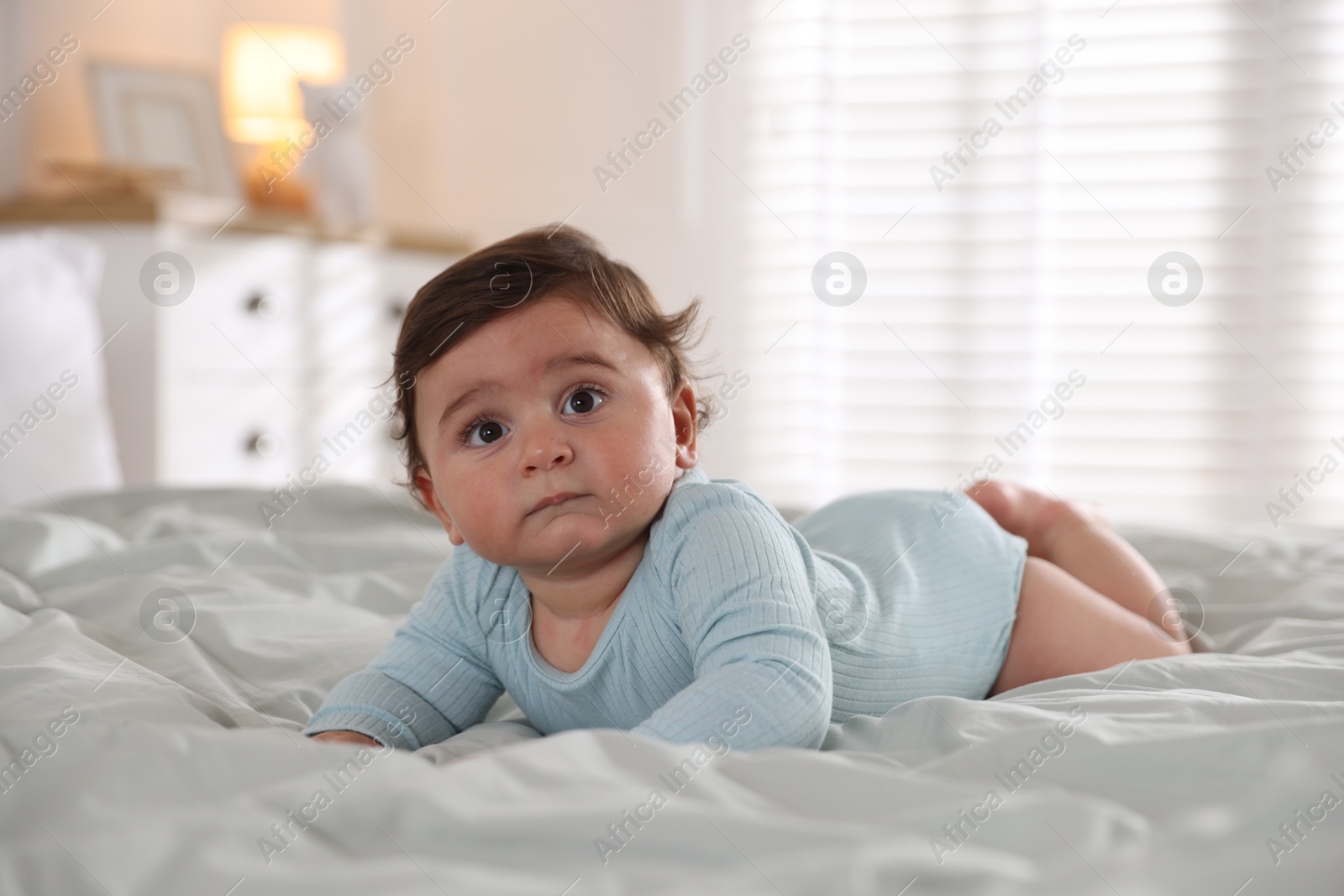 Photo of Cute little baby on bed at home
