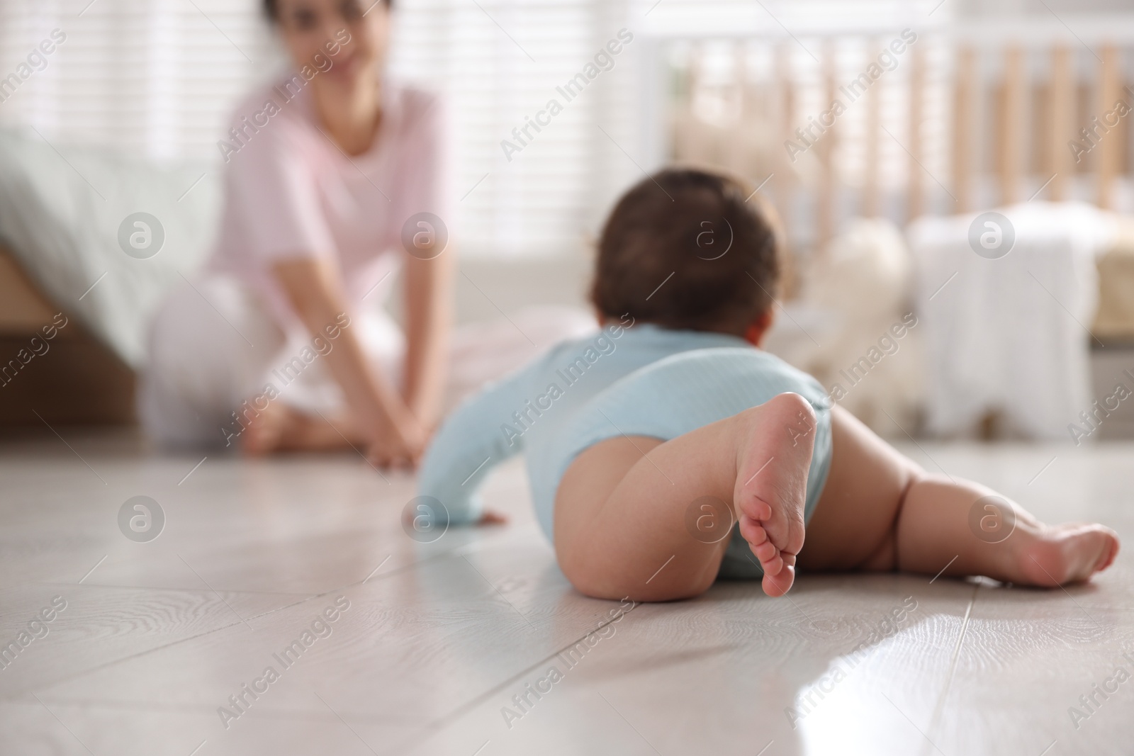 Mother with her cute little baby on floor indoors, selective focus Photo of Mother with her cute little baby on floor indoors, selective focus