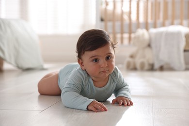 Photo of Cute little baby lying on floor at home