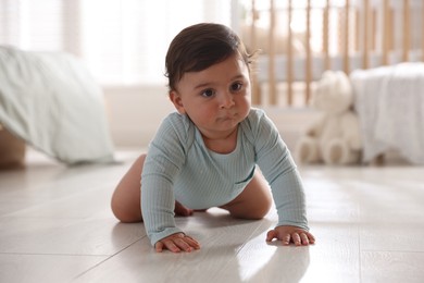 Photo of Cute little baby crawling on floor at home