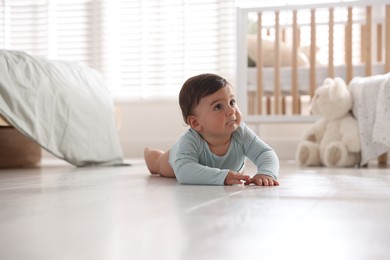 Photo of Cute little baby lying on floor at home