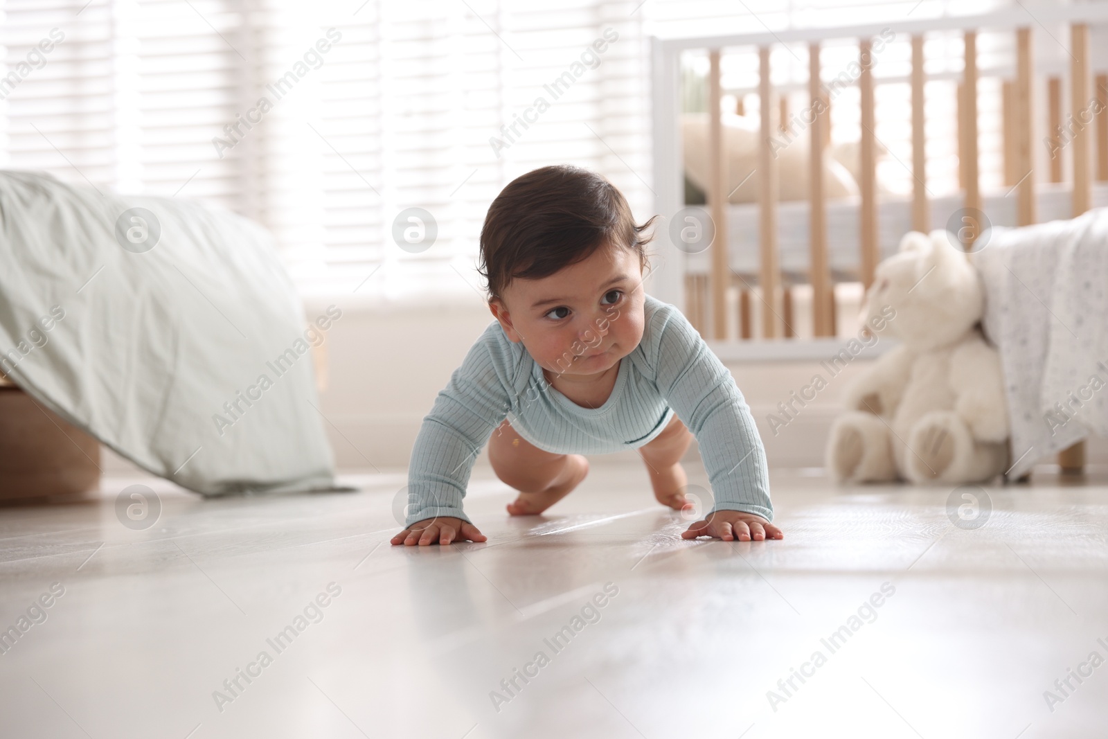 Photo of Cute little baby crawling on floor at home