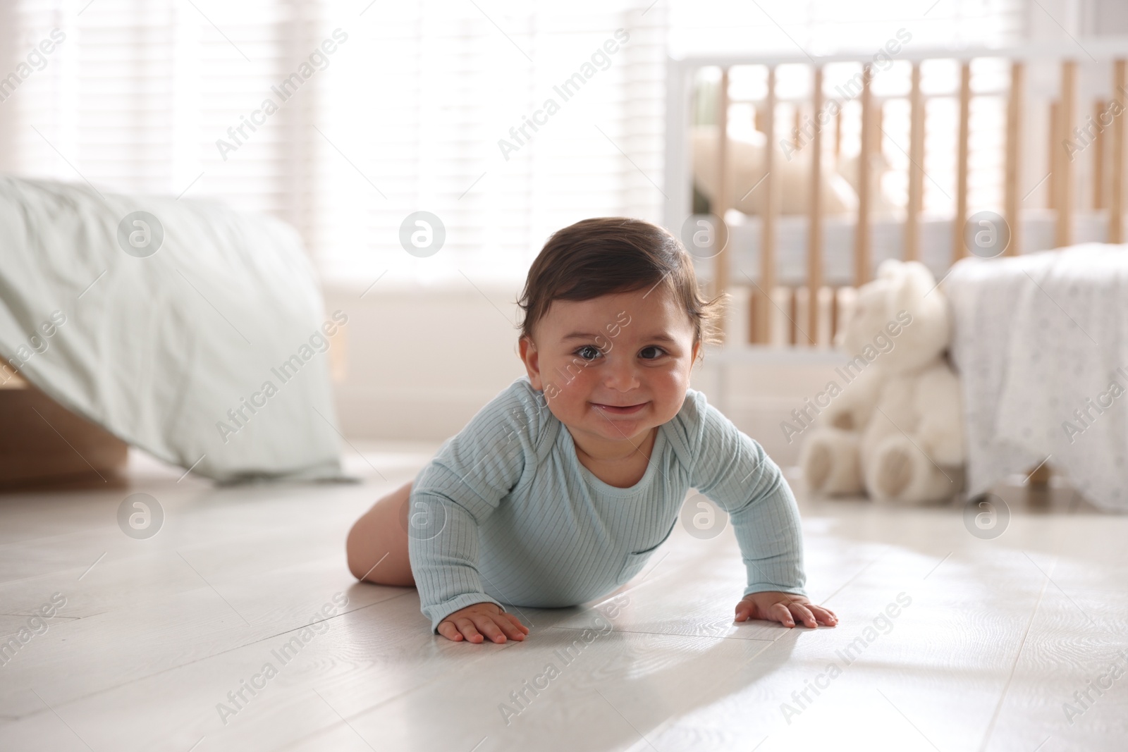 Photo of Cute little baby crawling on floor at home